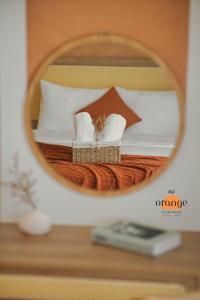 a mirror reflecting a bed with two towels on it at iRest Orange Tay Ho Lakeside Apartment in Hanoi