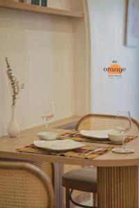 una mesa de madera con dos vasos y platos. en iRest Orange Tay Ho Lakeside Apartment en Hanoi