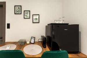 een bureau met een koelkast en 2 groene stoelen bij Frourio Lodge Α1 in Larisa