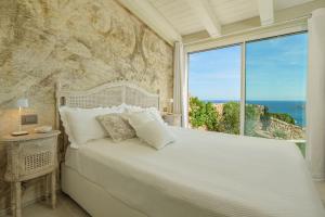 Un dormitorio con una cama grande y una ventana grande. en Villa con vista da sogno, en Porto Cervo 28 fotos más