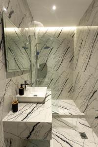 een witte badkamer met een wastafel en een spiegel bij Frourio Lodge Α1 in Larisa