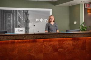 a woman is standing behind a reception desk at Hampton Inn Butte in Butte