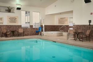 una piscina con sillas, una mesa y una bañera en Hampton Inn Butte en Butte