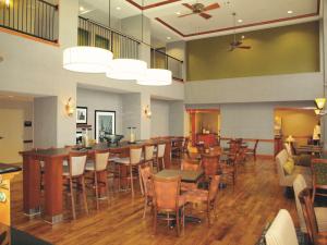 a restaurant with tables and chairs and a bar at Hampton Inn Clinton in Clinton