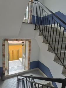 eine Treppe in einem Haus mit gelber Tür in der Unterkunft Ruggiero's Rooms in Neapel