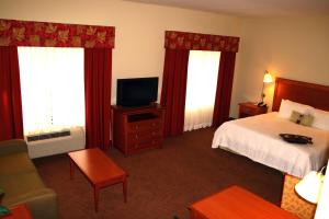 a hotel room with a bed and a television at Hampton Inn Clinton in Clinton