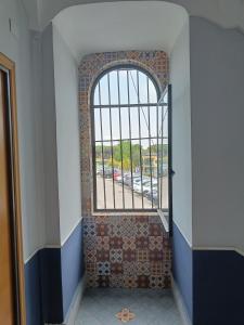 ein gewölbtes Fenster im Flur mit Fliesenboden in der Unterkunft Ruggiero's Rooms in Neapel