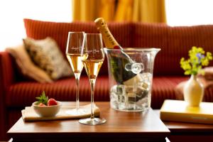 a table with three wine glasses and a bottle of champagne at Louisa's Place in Berlin