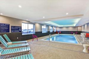 a swimming pool with lounge chairs next to a swimming pool at Tru By Hilton Richmond in Richmond