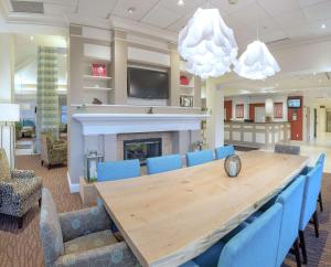 a conference room with a wooden table and blue chairs at Hilton Garden Inn Plymouth in Plymouth