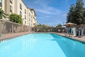 une grande piscine bleue en face d'un bâtiment dans l'établissement Hampton Inn and Suites Bakersfield / Highway 58, à Bakersfield