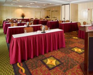a conference room with tables and chairs with red table cloth at Hilton Garden Inn Plymouth in Plymouth