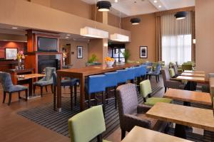 a restaurant with tables and chairs and a fireplace at Hampton Inn & Suites Tacoma in Tacoma