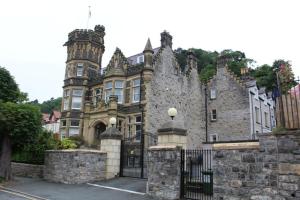 a large building with a gate in front of it at BODLONDEB CASTLE BED & BREAKFAST { CENTRAL LLANDUDNO} in Llandudno