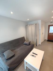 a living room with a couch and a table at Studio 27m2 77410 Claye Souilly CDG Disney Astérix in Claye-Souilly