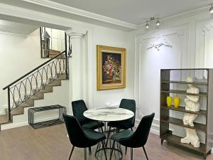 a dining room with a table and chairs and a staircase at Sea Pearl Apartments in Vlorë