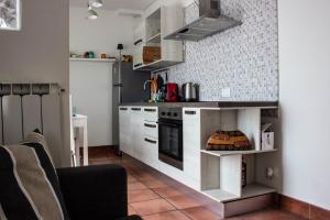 uma cozinha com armários brancos e um forno com placa de fogão em [Terrazza privata] Venezia Mestre em Marghera