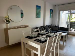 - un salon avec une table et un canapé dans l'établissement Las Terrazas De La Torre Golf Resort, à Las Pedreñas