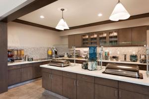 a large kitchen with brown cabinets and a counter top at Homewood Suites by Hilton Gateway Hills Nashua in Nashua