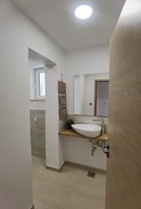 uma casa de banho com um lavatório e um espelho em Cozy waterfront home em Šibenik
