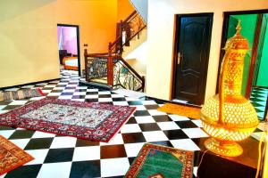 a room with carpets on a checkered floor at Dar Fadma in Ouarzazate