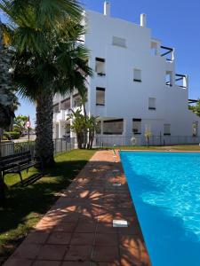un bâtiment avec une piscine en face d'un bâtiment dans l'établissement Las Terrazas De La Torre Golf Resort, à Las Pedreñas
