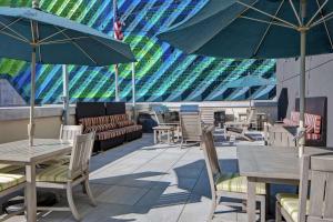 un patio esterno con tavoli, sedie e ombrelloni di Home2 Suites By Hilton Charlotte Uptown a Charlotte