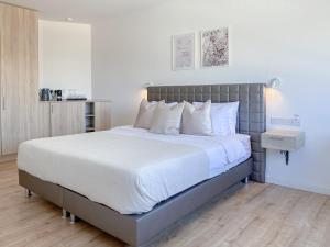 um quarto com uma cama grande e almofadas brancas em Phaedrus Living: Plateia Suite Brillante em Nicósia