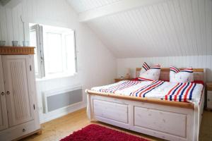 um quarto com uma cama com um tapete vermelho e uma janela em Haus am See mit Privatstrand, Kamin und Sauna em Löbnitz