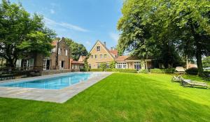 a large yard with a swimming pool in front of a house at Landhaus Eggert in Münster