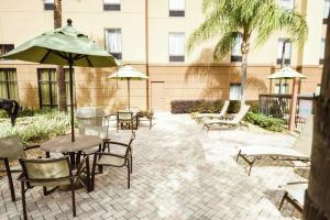 een patio met stoelen, tafels en parasols bij Hampton Inn & Suites Ocala - Belleview in Marion Oaks