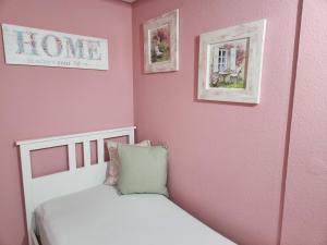 um quarto com uma cama e uma parede rosa em Ferienwohnung Salut em Saarbrücken