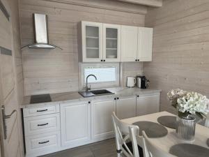 a kitchen with white cabinets and a table and a sink at Silver Park in Gąski