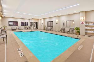 a large pool in a hotel with chairs and tables at Hampton Inn by Hilton Detroit Dearborn, MI in Dearborn