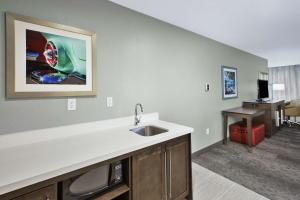 a kitchen with a sink and a desk in a room at Hampton Inn by Hilton Detroit Dearborn, MI in Dearborn