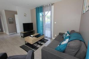 a living room with a couch and a tv at Maison climatisée avec parking in Montauban