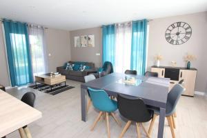 a living room with a dining room table and chairs at Maison climatisée avec parking in Montauban