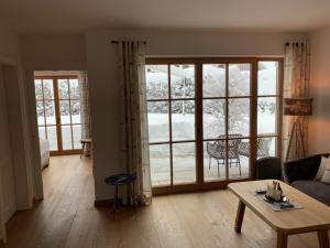a living room with a table and a large window at Ferienwohnung Max 3 in Garmisch-Partenkirchen