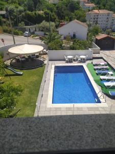 eine Aussicht über einen Pool mit Stühlen und einem Tisch in der Unterkunft Retiro da Estrela in Seia