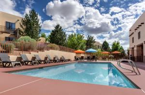een zwembad met stoelen en parasols in een resort bij Homewood Suites by Hilton Santa Fe-North in Pojoaque
