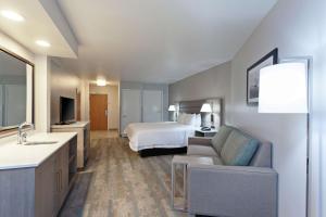 duży pokój hotelowy z łóżkiem i kanapą w obiekcie Hampton Inn & Suites Hermosa Beach w mieście Hermosa Beach