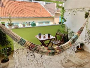 una hamaca en un balcón con una mesa y una habitación en Hostel New Ipanema, en Río de Janeiro