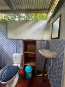 a small bathroom with a toilet and a sink at Stay at the river house in Iquitos