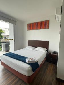 1 dormitorio con 1 cama grande y suelo de madera en Ayenda Apartamento Turistico Distrito 9 90, en Cali
