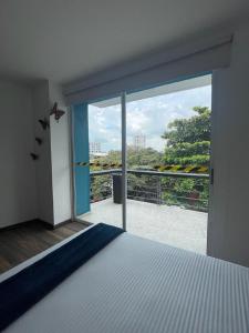 a bedroom with a bed and a large window at Ayenda Apartamento Turistico Distrito 9 90 in Cali