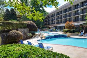 a hotel with a pool and chairs in front of a building at Hilton Peachtree City Atlanta Hotel & Conference Center in Peachtree City