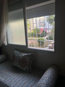 um quarto com 2 janelas e uma cama com uma almofada em Appartement hay el fath résidence calme propre em Rabat