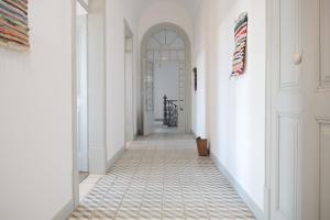 un corridoio con pareti bianche e pavimento piastrellato di A Janela do Palacete a Reguengos de Monsaraz