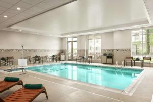 a pool in a hotel room with chairs and tables at Homewood Suites By Hilton Worcester in Worcester