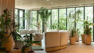 a room with a bunch of plants and white chairs at 23 Hotel Medellin in Medellín +37 photos